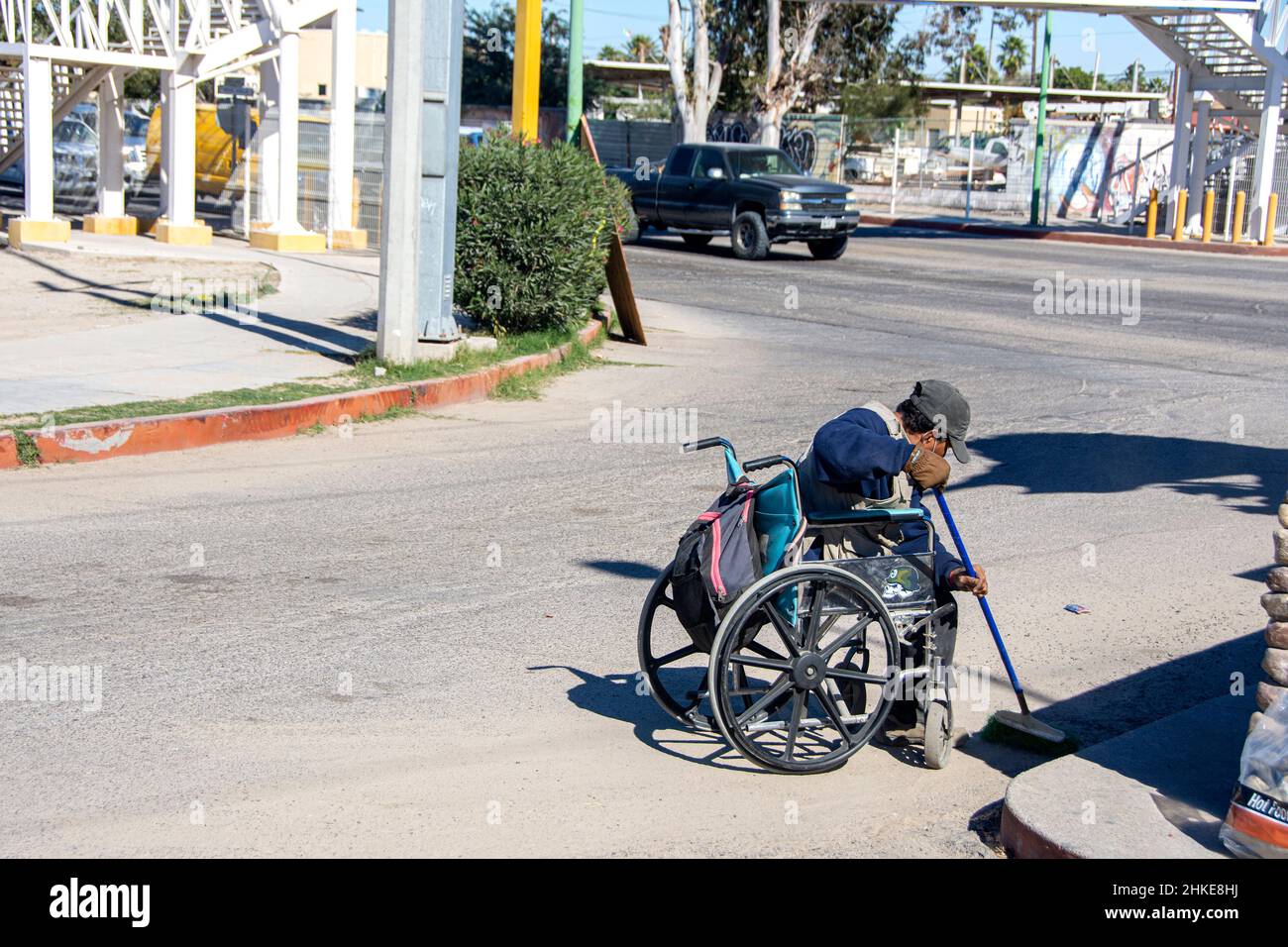 Ein Mexikaner im Rollstuhl verbringt seine Tage damit, Müll entlang der Rinnen der Straßen von Puerto Penasco, Sonora, Baja California, Mexiko, abzuholen. Stockfoto