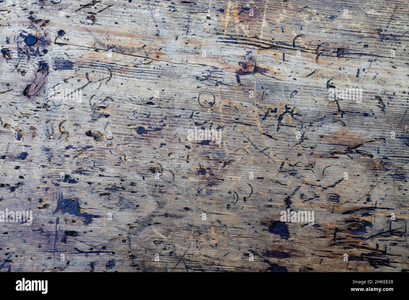 Nahaufnahme eines alten Holzbretts, das durch Messerfurchen ruiniert wurde Stockfoto