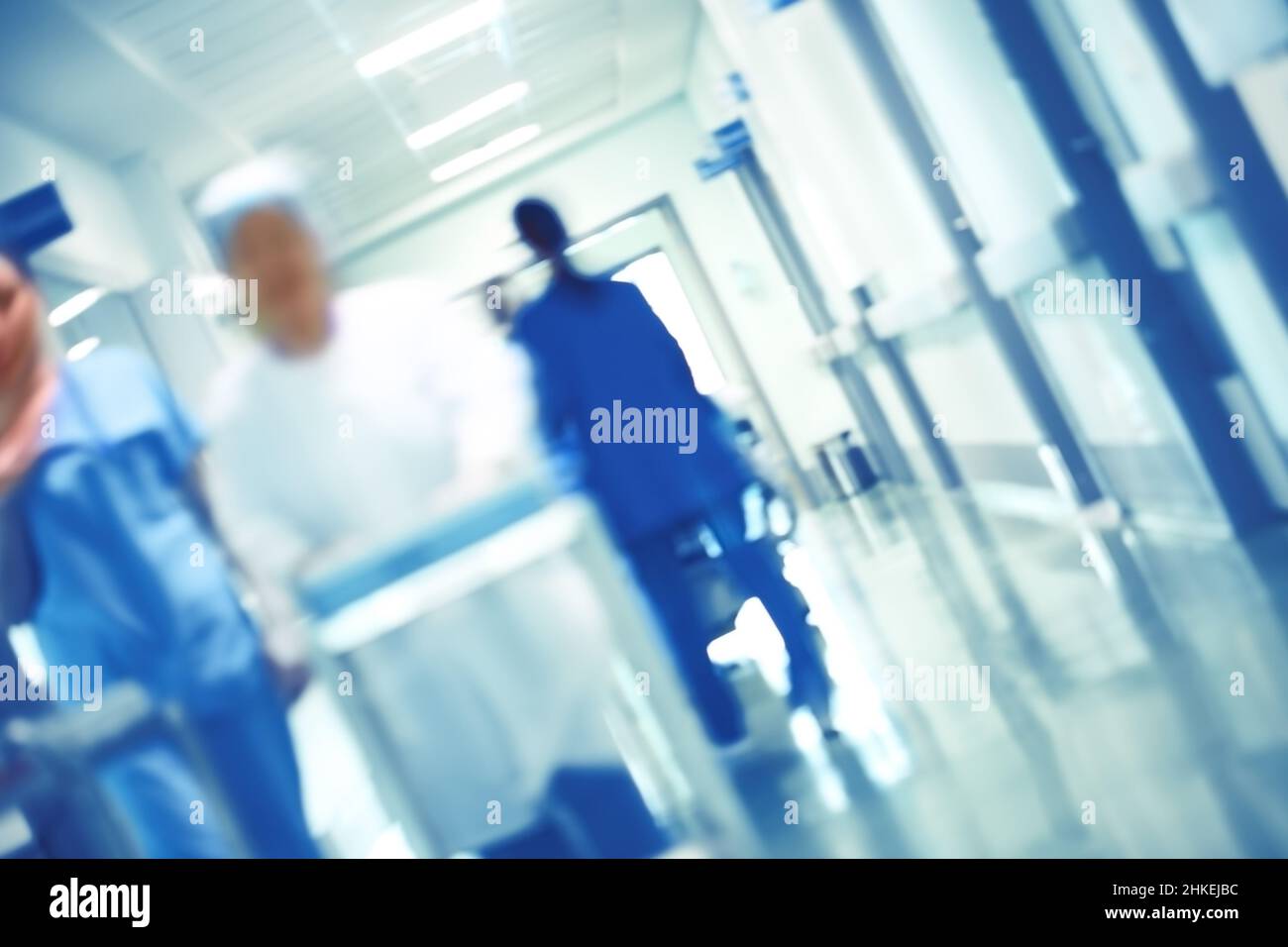 Verschwommene Zahlen von herumgehendem medizinischem Personal im Krankenhausflur, unfokussierter Hintergrund. Stockfoto
