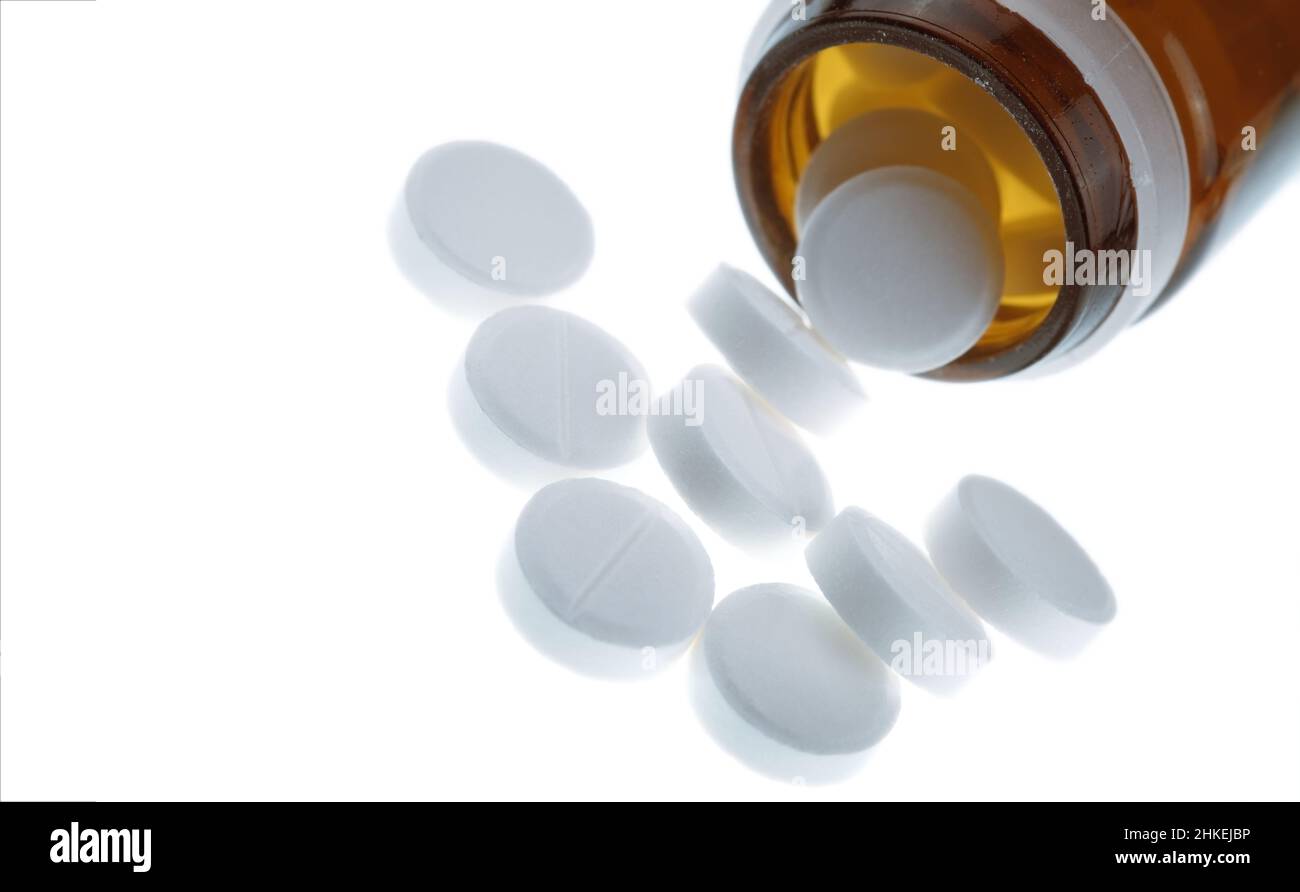 Pillen aus einer Flasche verstreut, isoliert auf einem weißen Hintergrund mit leerem Platz für Ihren Text. Stockfoto