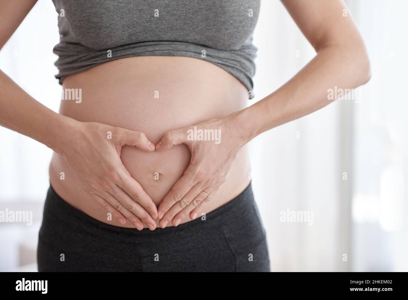 Was Sie zu erwarten haben, wenn Sie es erwarten. Kurzer Schuss einer Schwangeren, die in ihrem Haus steht. Stockfoto