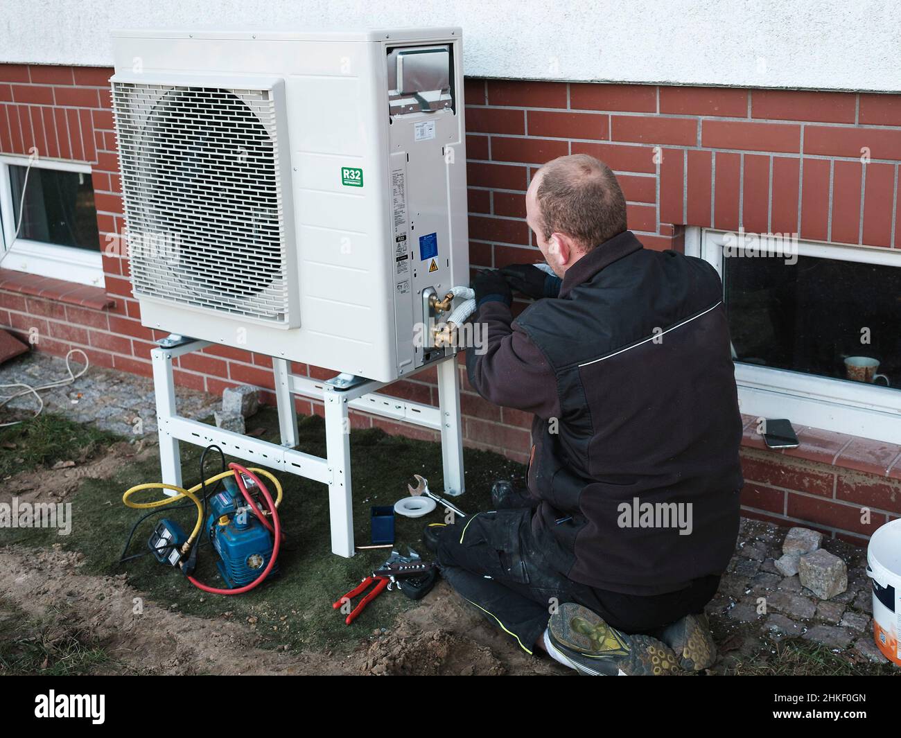Der Installierer installiert die Wärmepumpe in einem Einfamilienhaus Stockfoto