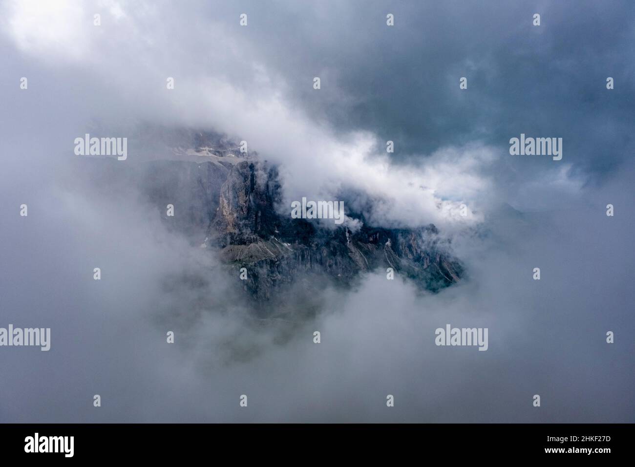 Felswände der Sella-Gruppe, bedeckt mit Wolken, vom Gipfel des Grand Cum aus gesehen. Stockfoto