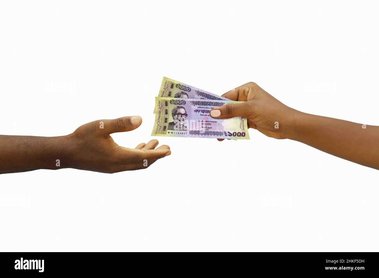 Hand, die einer anderen Hand 1000 Taka-Notizen aus Bangladesch gibt. Hand, die Geld erhält Stockfoto