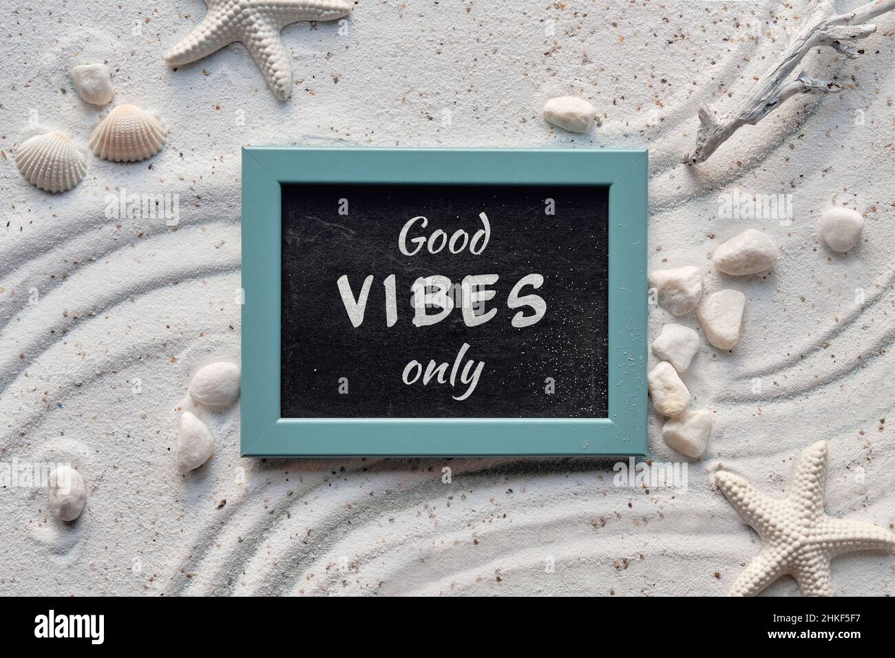 Hintergrund mit weißem Sand mit Muscheln, Seesterne. Gute Stimmung nur Text auf Tafel in mintgrünem Rahmen. Stockfoto