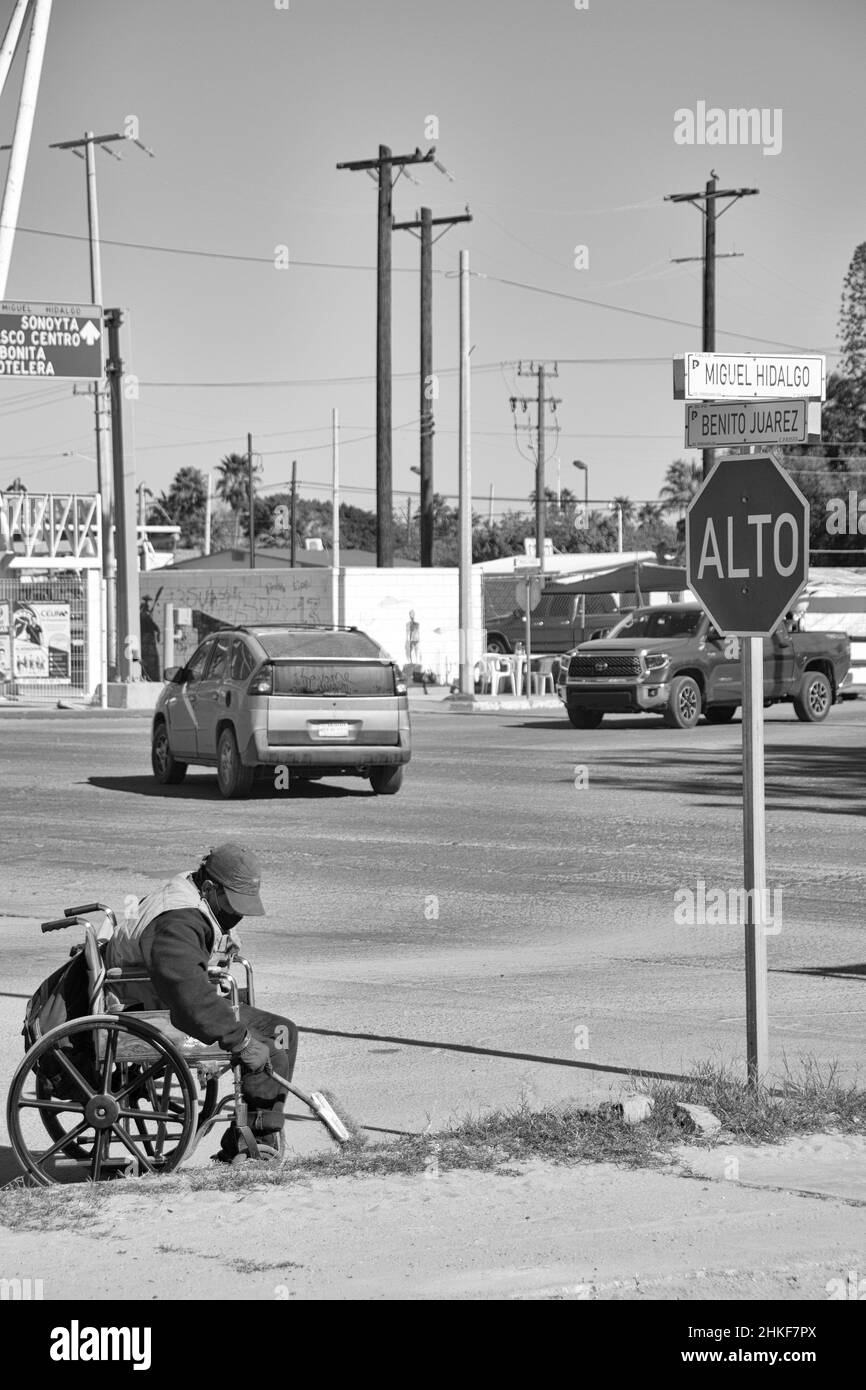 Ein Mexikaner im Rollstuhl verbringt seine Tage damit, Müll entlang der Rinnen der Straßen von Puerto Penasco, Sonora, Baja California, Mexiko, abzuholen. Stockfoto