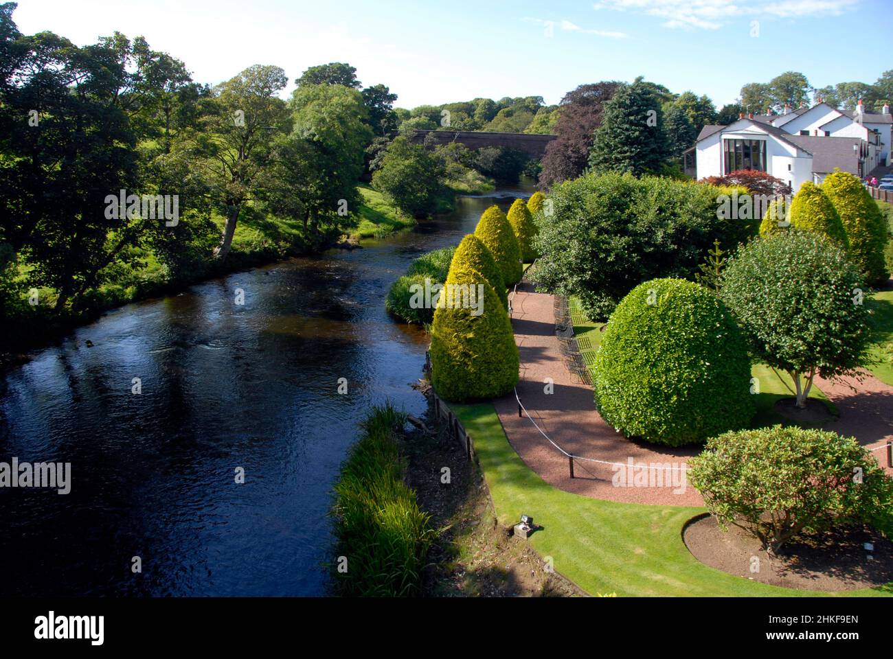 Blick auf den Fluss Doon und attraktive Gärten von Brig o' Doon, Ayrshire, Schottland, mit Bäumen, die Schatten spenden Stockfoto