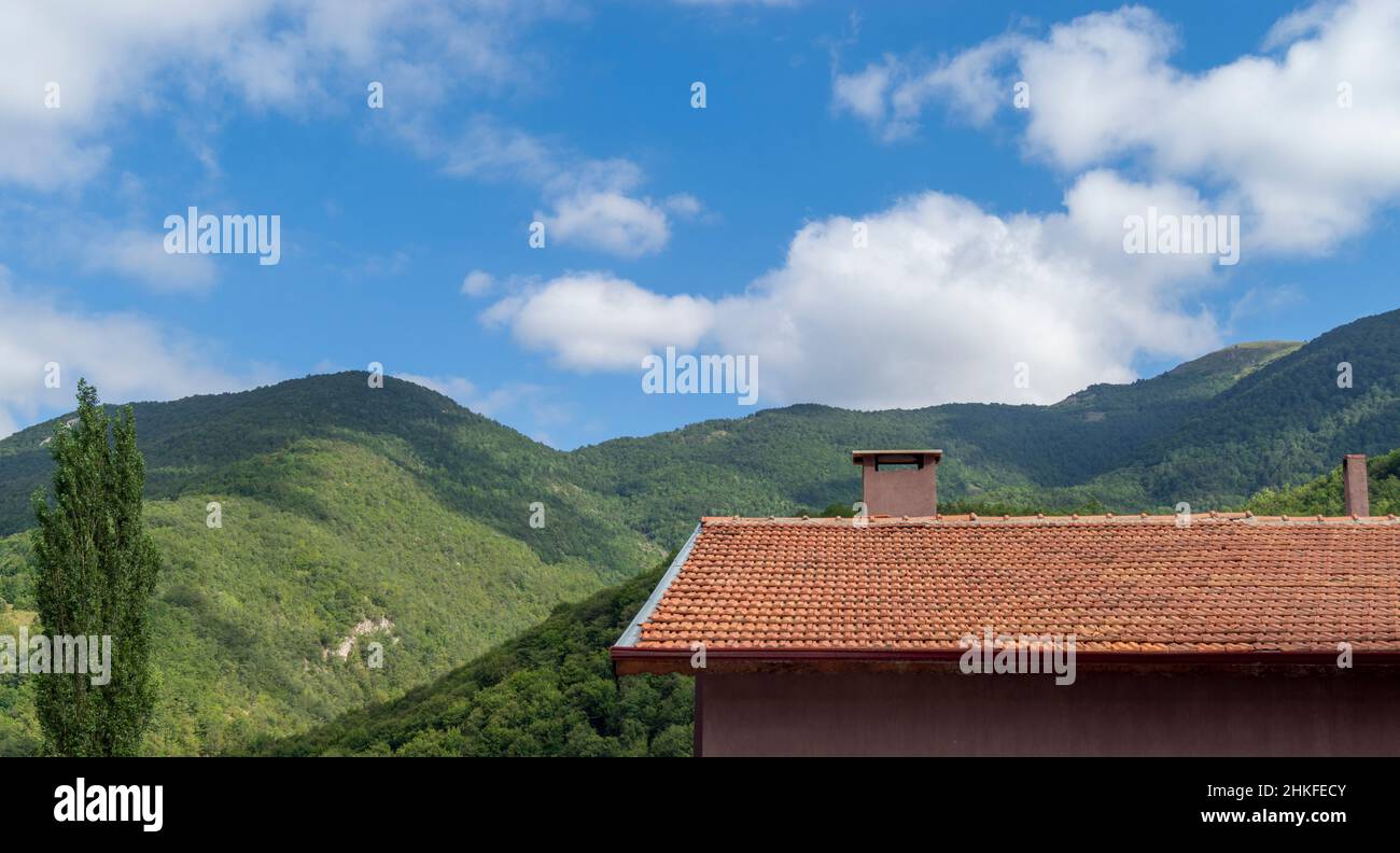 Ein wunderbares Naturhaus mit einem Dach im üppigen Wald. Bergdorf Haus. lodge mit Dach. Rotes Dach Waldhaus. Stockfoto