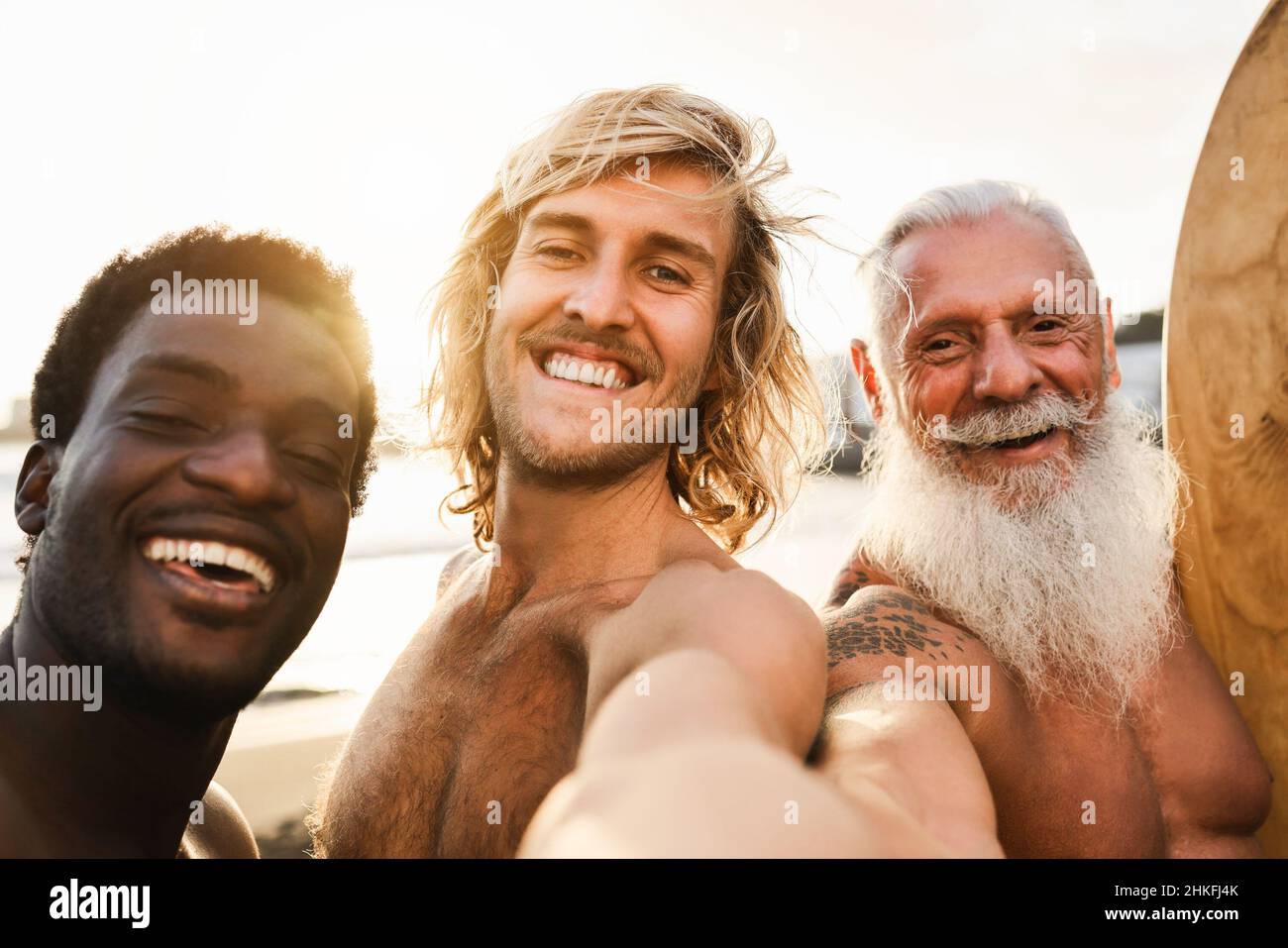 Multi-Generationen-Surfer-Freunde haben Spaß beim Selfie am Strand nach der Surf-Session - Fokus auf Center-Kerl Gesicht Stockfoto