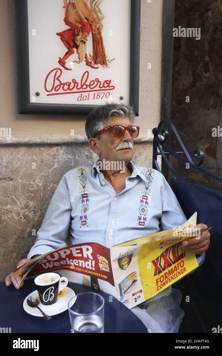 Italien, Sizilien, Taormina, alter sizilianischer Gentleman mit roten Gläsern und Zeitung in der Hand im Café barbero am corso Umberto im mittelalterlichen Zentrum Stockfoto