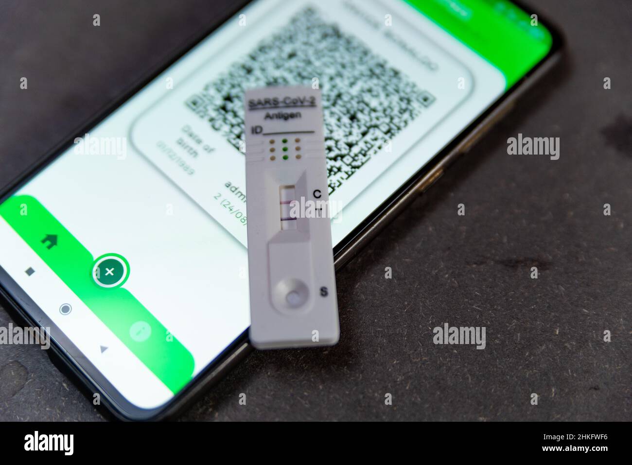 Spanien. 04th. Februar 2022. Ein positiver Covid-Schnelltest, auch als Antigentest oder Lateral-Flow-Test bekannt, wird in einer Nahaufnahme auf einem Tisch zusammen mit einem Mobiltelefon, das am 04. Februar 2022 einen Green Pass oder COvid-Pass in Barcelona, Spanien zeigt, angezeigt. Die Nachfrage nach Covid-Selbsttests ist aufgrund der Ausbreitung der Omicron-Variante covid-19 exponentiell gestiegen. (Foto von Davide Bonaldo/Sipa USA) Quelle: SIPA USA/Alamy Live News Stockfoto