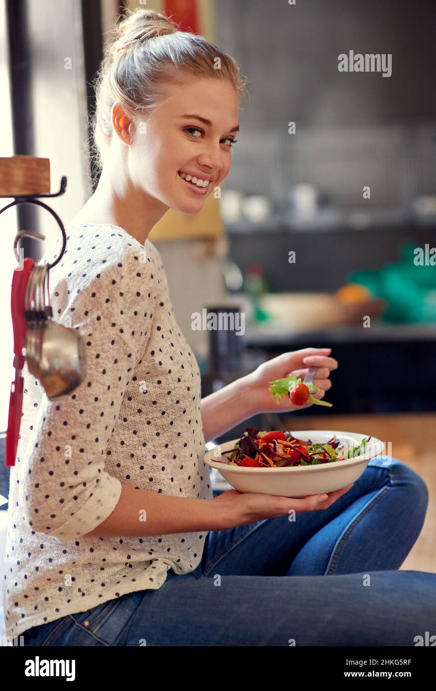 Tolle Ideen für das Mittagessen. Porträt einer jungen Frau, die in ihrer Küche einen gesunden Salat isst. Stockfoto