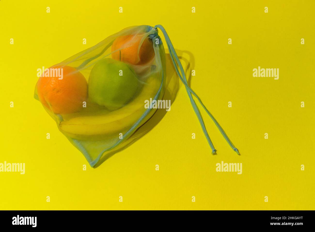 Früchte in einem Einwegbeutel auf gelbem Hintergrund. Stockfoto
