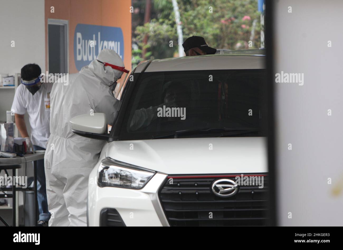 Ein Mitarbeiter des Gesundheitswesens führt während eines Drive-Thru-Service am 4. Februar 2022 bei einem Drive-Thru-Test des Typs COVID-19 in Bogor City, West Java, Indonesien, einen PCR-Abstrichtest an einer Person durch. Wie das Gesundheitsministerium erklärte, hatte Indonesien begonnen, in die dritte Welle von COVID-19 einzutreten, die durch die Zunahme der täglichen Fälle in der vergangenen Woche aufgrund der Übertragung der neuen COVID-19-Variante gekennzeichnet war. (Foto von Adriana/INA Photo Agency/Sipa USA) Stockfoto