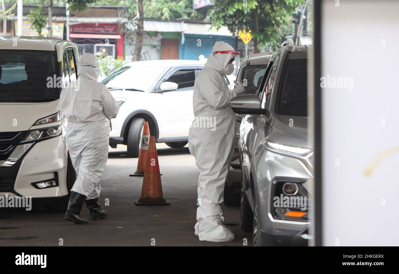 Ein Mitarbeiter des Gesundheitswesens nimmt während eines Drive-Thru-Service am 4. Februar 2022 bei einem Drive-Thru-COVID-19-Test in Bogor City, West Java, Indonesien, einen PCR-Abstrichtest ab. Wie das Gesundheitsministerium erklärte, hatte Indonesien begonnen, in die dritte Welle von COVID-19 einzutreten, die durch die Zunahme der täglichen Fälle in der vergangenen Woche aufgrund der Übertragung der neuen COVID-19-Variante gekennzeichnet war. (Foto von Adriana/INA Photo Agency/Sipa USA) Stockfoto