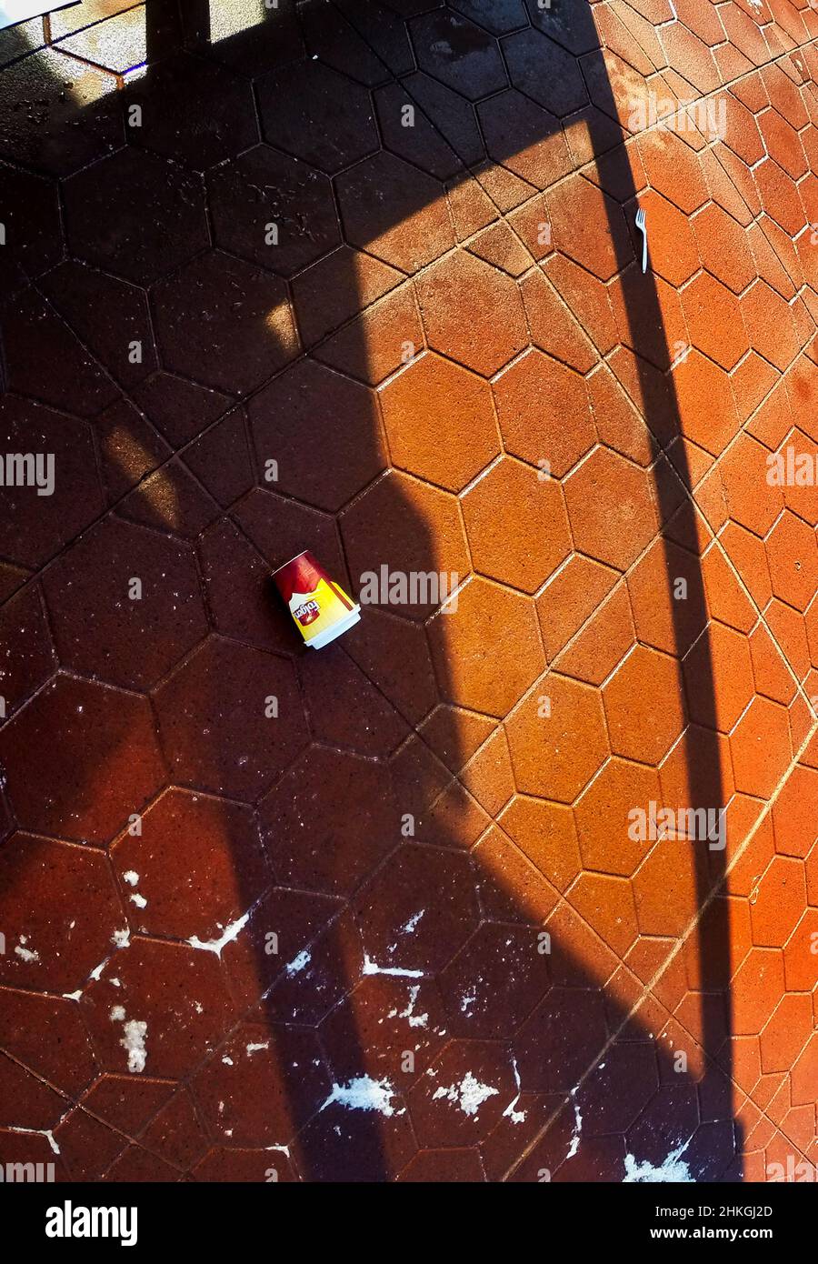 Entsorgte Kaffeetasse auf der Oberfläche eines Bahnhofsbühns Stockfoto