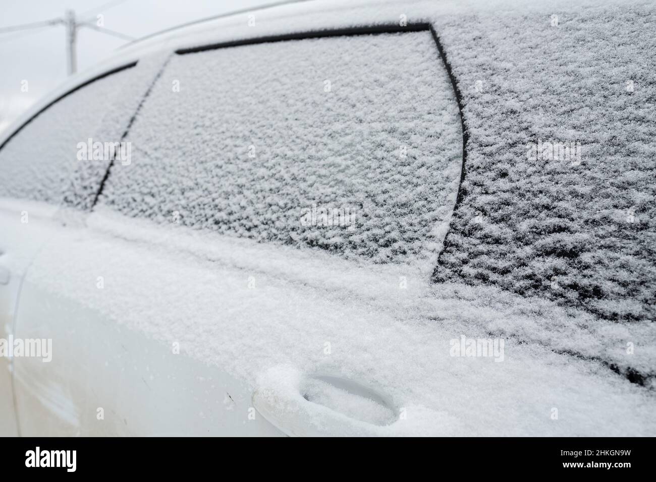 Verschneite Türen und Fenster eines Autos, im Freien, an einem Wintertag. Stockfoto