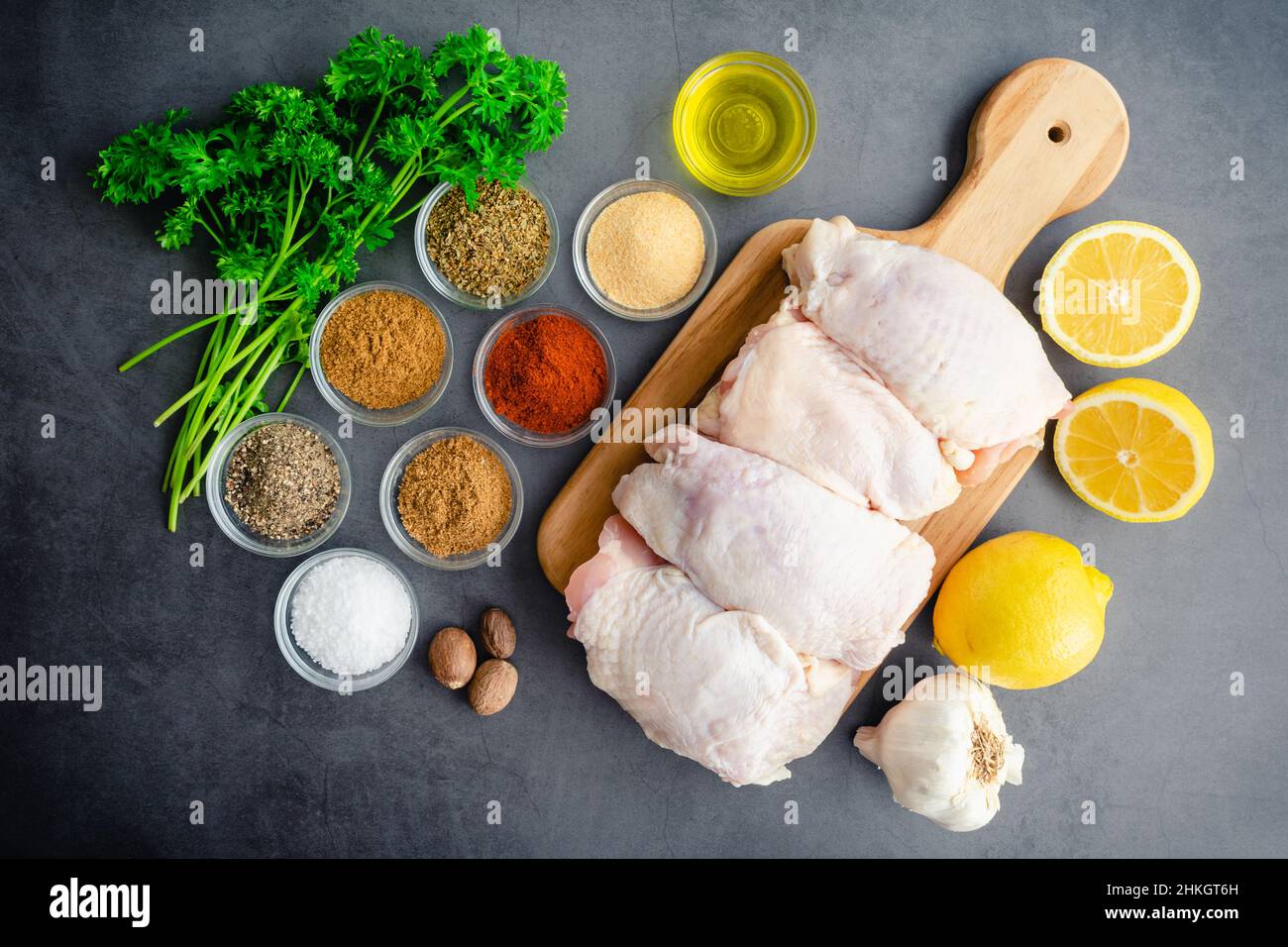 Olivenöl Chicken Thighs Mediterranean Style Zutaten: Rohe Chicken Thighs mit Olivenöl, Zitrone, Kräutern und Gewürzen Stockfoto