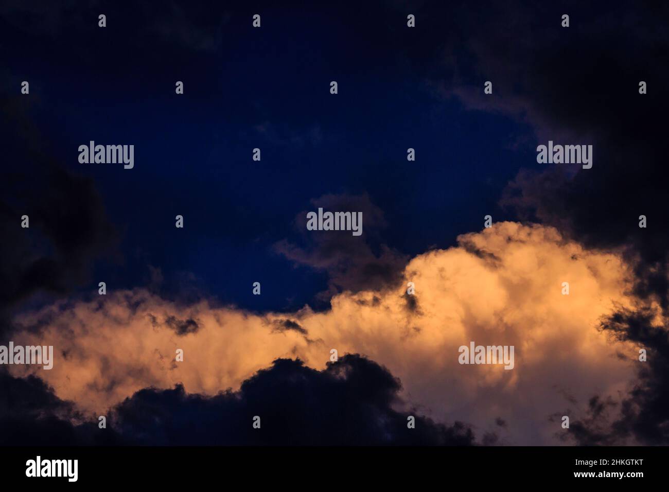 Dramatische, reiche und vielschichtige Wolkenzusammenstöße in hellem Weiß, Blau, Grau und Schwarz. Stockfoto