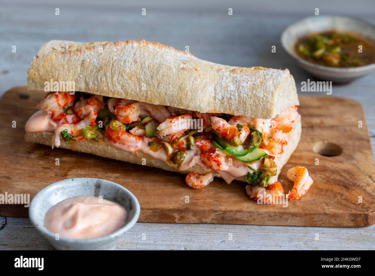 Steingebackene Baquette mit Krebsen, eingelegten Gurken, würzigem Dressing und sriracha-Mayonnaise Stockfoto