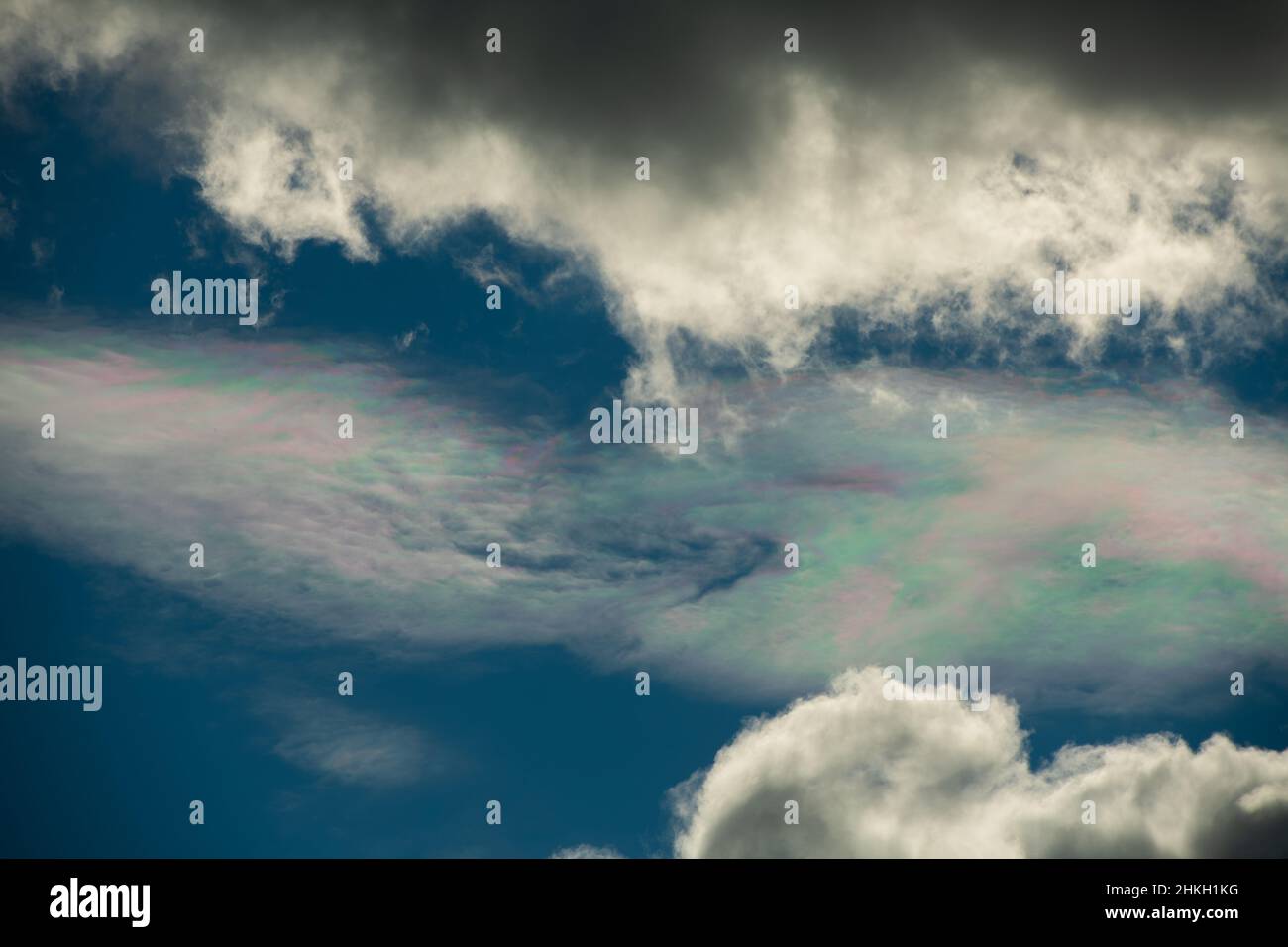 Verschiedene Farben in Wolke am blauen Himmel zwischen weißen Wolken Blaupinken und Grünsonnen Reflexion in Wolken am blauen Himmel atmosphärische Wirkung oben Stockfoto