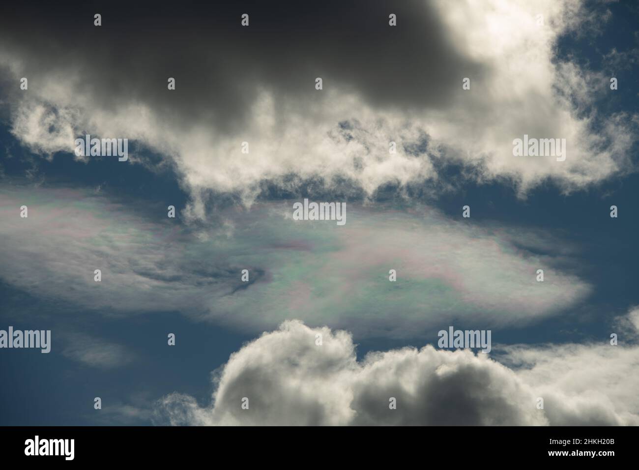 Verschiedene Farben in Wolke am blauen Himmel zwischen weißen Wolken Blaupinken und Grünsonnen Reflexion in Wolken am blauen Himmel atmosphärische Wirkung oben Stockfoto