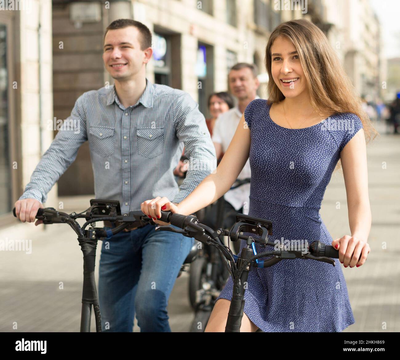 Freunde von Touristen verschiedener Generationen genießen eine Fahrt mit Elektrorollern Stockfoto