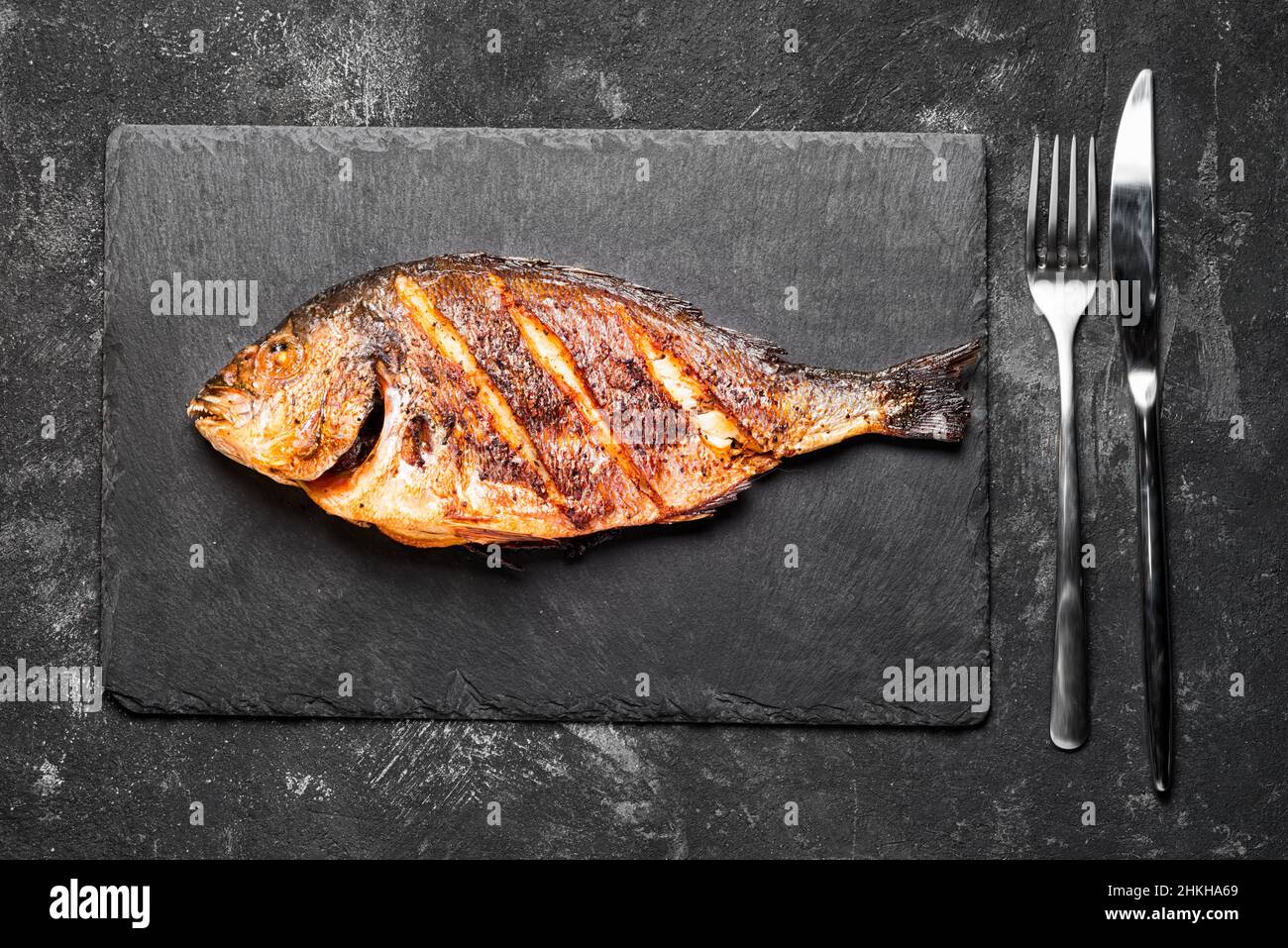 Gegrilltes dorada nur auf einem schwarzen Steintablett von oben. Stockfoto