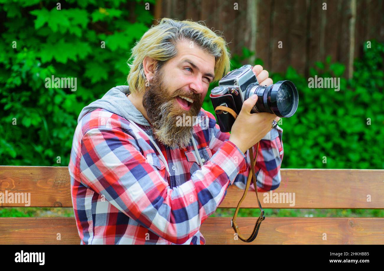 Fotograf, der mit einer professionellen Kamera fotografiert. Hipster mit Fotokamera in der Stadt. Reporter. Stockfoto