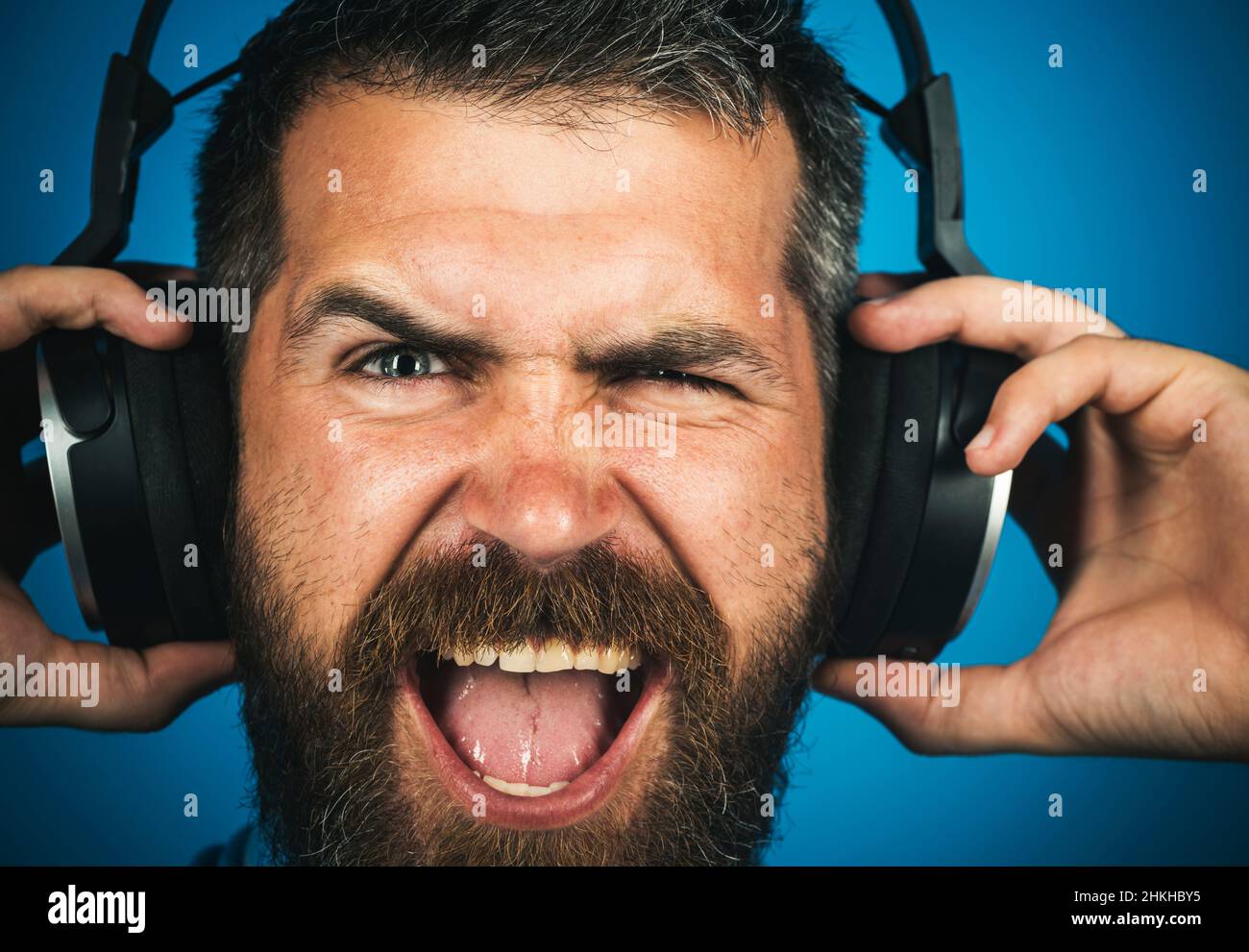 Happy Bearded Mann mit Kopfhörern, die Musik hören. Perfekter Song. Lächelnder Mann mit Ohrhörern. Nahaufnahme Stockfoto