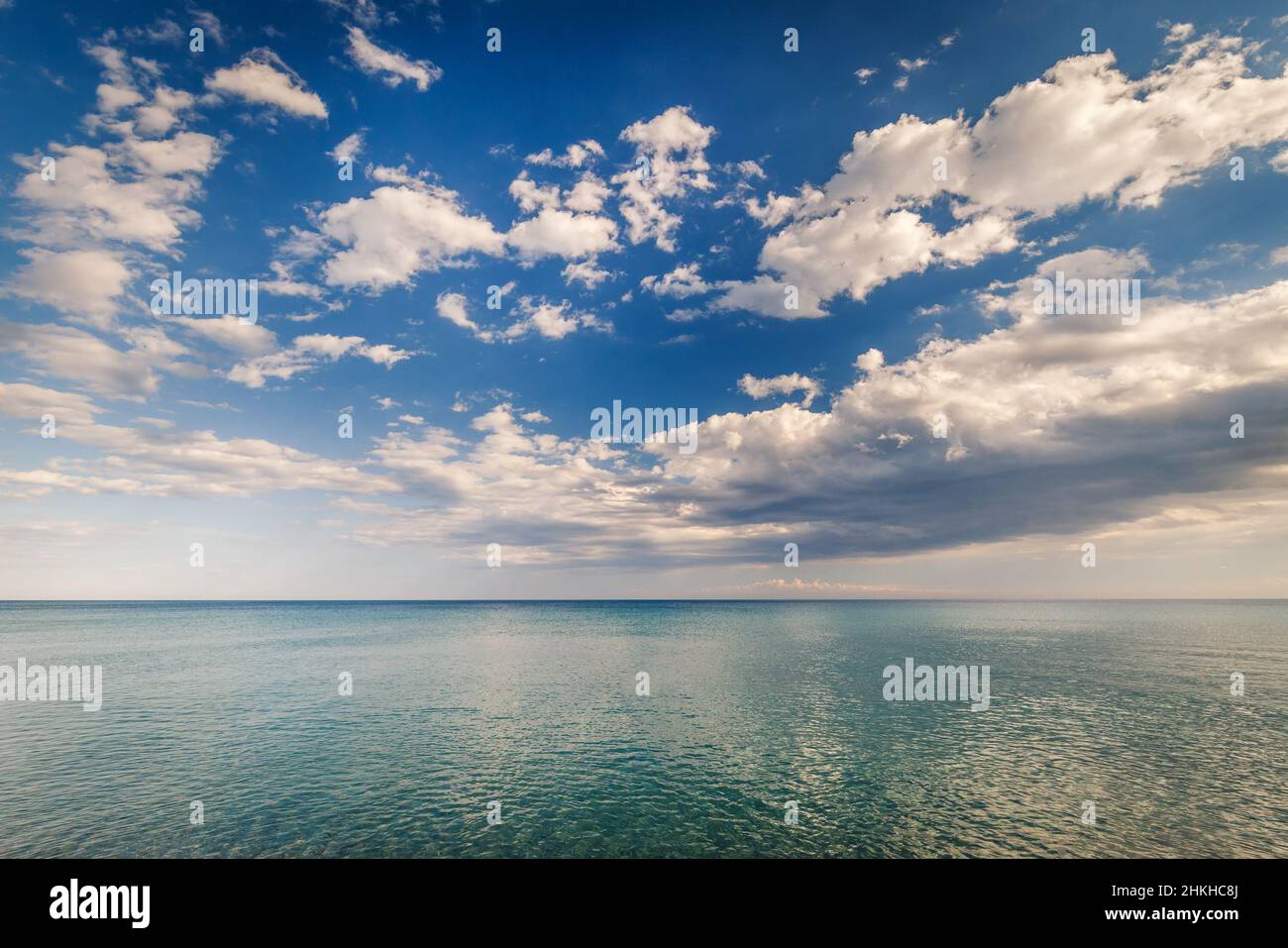 Ruhiges türkisfarbenes Meer und Wolken am blauen Himmel Stockfoto