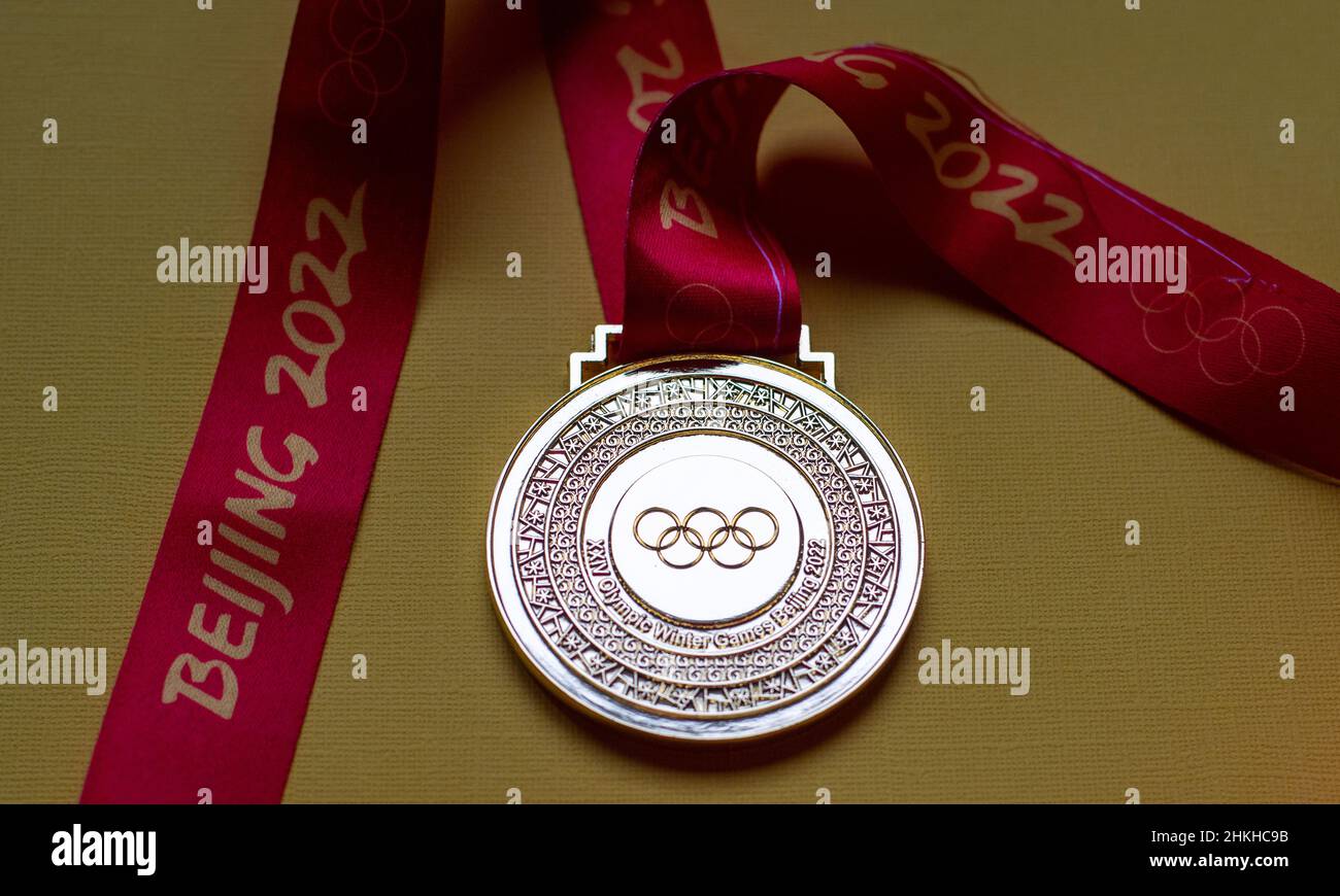 14. Januar 2022, Peking, China. Goldmedaille der XXIV. Olympischen Winterspiele auf gelbem Hintergrund. Stockfoto