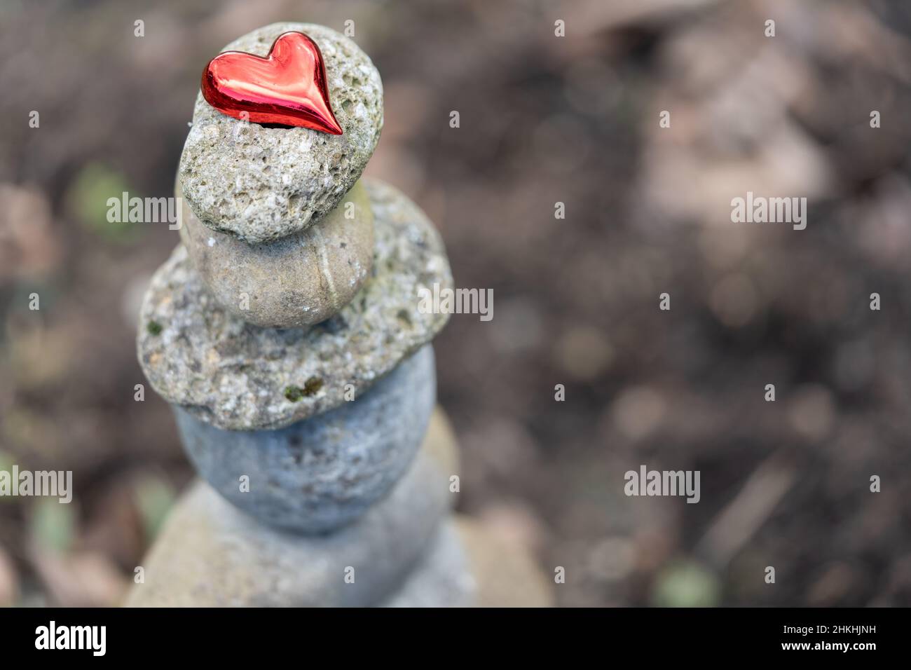Selektiver Fokus auf rotes Herz auf einem Steinhaufen. Stabilität, Gesundheit oder Liebe Konzept für Valentinstag. Stockfoto