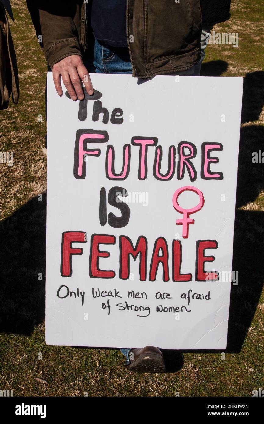 Person in Jeans und Lederjacke mit Protestschild - die Zukunft ist weiblich nur schwache Männer haben Angst vor starken Frauen Stockfoto