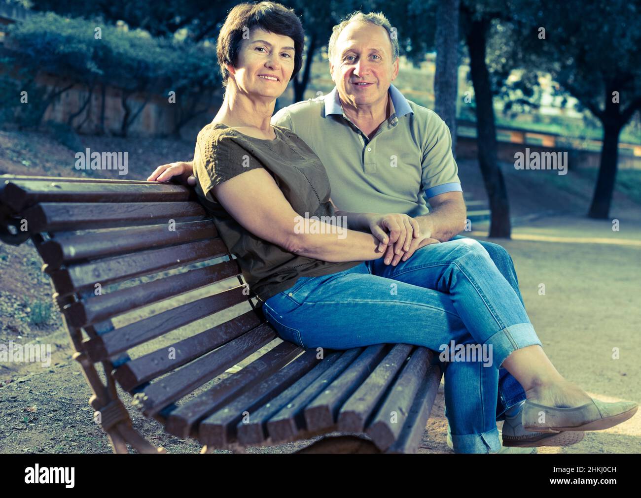 Ältere Männer und Frauen umarmen sich auf der Bank Stockfoto