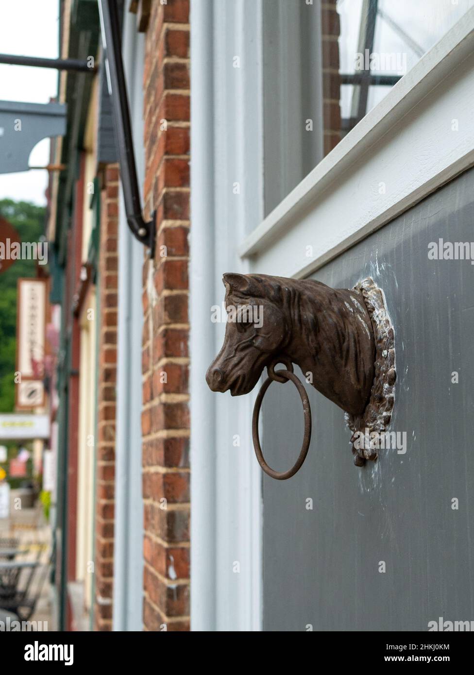 Alter Pferdekopf aus Metall und Ring an der Wand des Gebäudes befestigt. Stockfoto