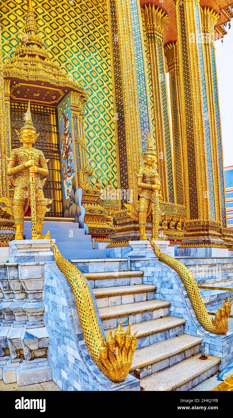 BANGKOK, THAILAND - 12. MAI 2019: Der Seiteneingang von Prasat Phra Thep Bidon wird mit vergoldeten Skulpturen von Yakshas und fünfköpfigen gekrönten Phaya bewacht Stockfoto