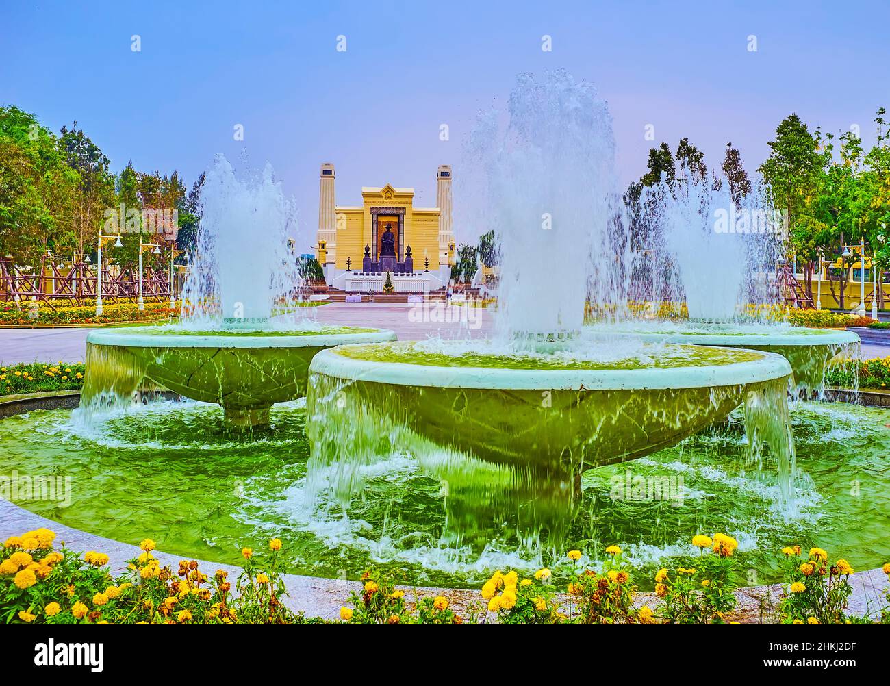 Der Blick durch die Brunnen auf das Grün des kleinen Parks mit dem King Rama I Monument im Hintergrund, Bangkok, Thailand Stockfoto