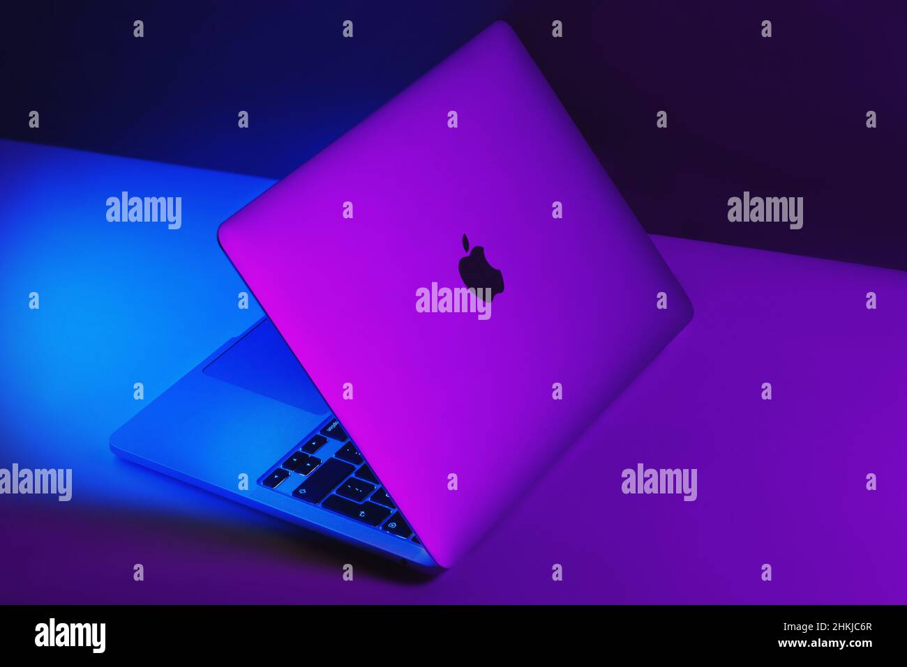 Izmir, Türkei - 10. Januar 2022: Apple Brand M1 Modell Macbook Pro Laptop-Computer mit violetten und blauen Lichtern zur Hälfte eröffnet Stockfoto