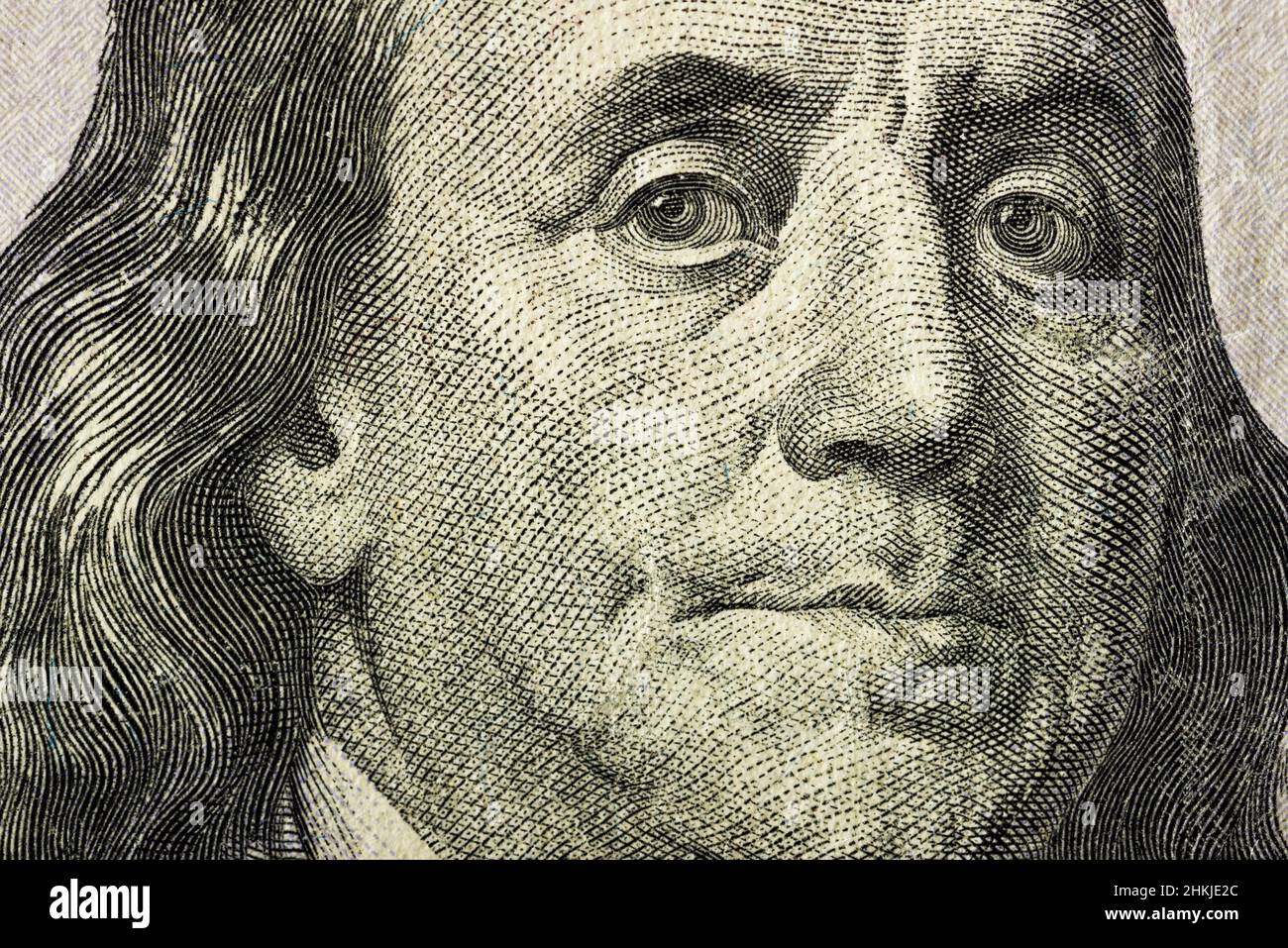 Nahaufnahme des Gesichts von Benjamin Franklin auf der 100-Dollar-Banknote. Banknote in nicht perfektem Zustand. Es gibt einige Schäden daran. Stockfoto