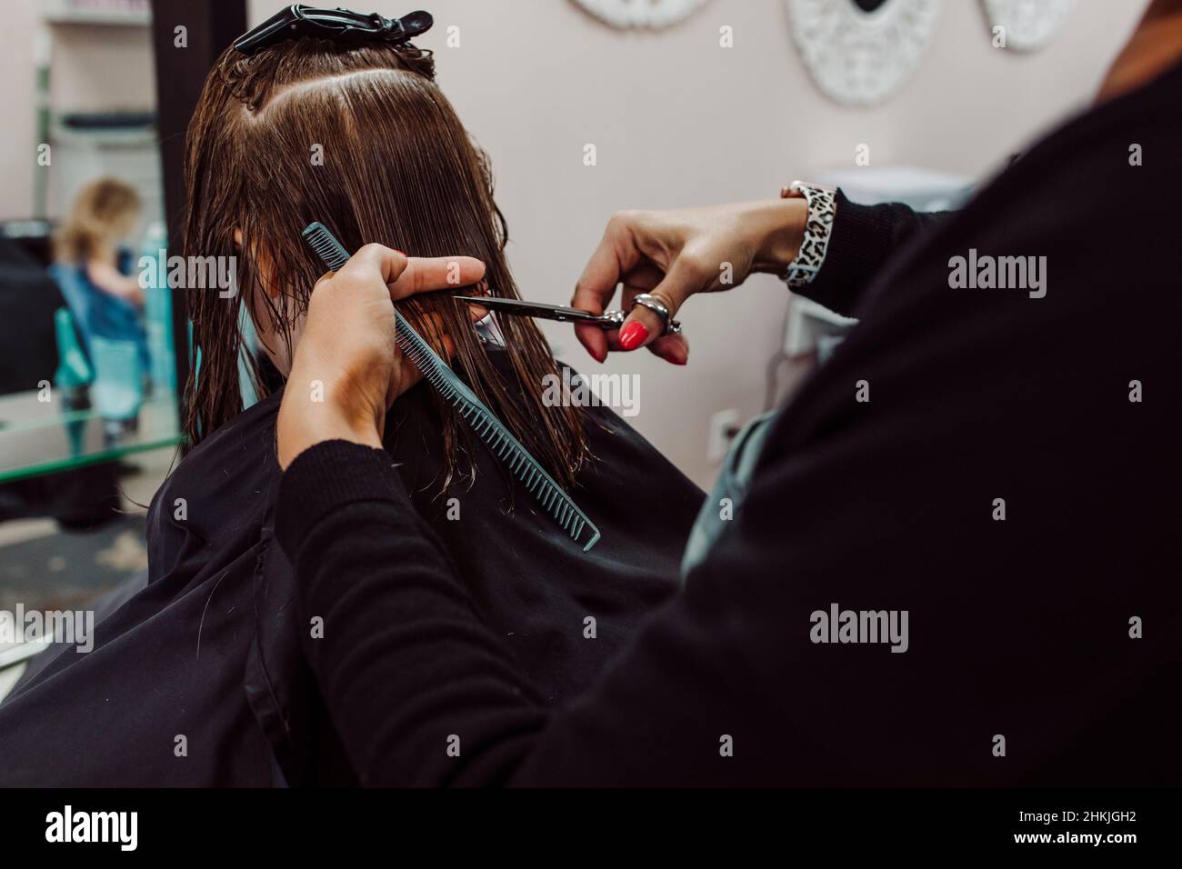 Kleines Mädchen, das von einer Frau einen Haarschnitt bekommt Stockfoto