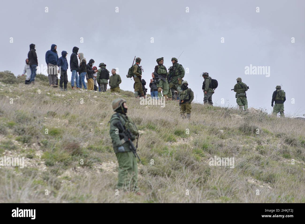 Burin, Palästina. 04th. Februar 2022. IDF-Soldaten verhinderten, dass jüdische Siedler die Aktivisten erreichten. Hunderte von israelischen und palästinensischen Friedensaktivisten hatten im palästinensischen Dorf Burin, unterhalb des jüdischen illegalen Außenpostens von Givát Ronen, Olivenbäume gepflanzt. Zwei Wochen vor der Veranstaltung wurde eine Gruppe jüdischer Friedensaktivisten, die zur Olivenplantage eintrafen, von der Jugend von Givát Ronen gewaltsam angegriffen. Heute hatten sich die IDF-Truppen zwischen den Aktivisten und den Siedlern getrennt. Ein israelischer Aktivist wurde während der Veranstaltung verhaftet. Burin, Palästina. Februar 04th 2022. (Foto von Matan Golan/S Stockfoto