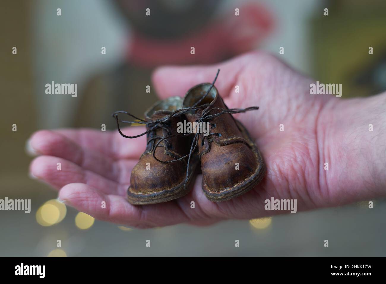 Das Konzept der Leichtindustrie für die Herstellung stilvoller, modischer brauner Leder-Kleinschuhe mit kleinen Füßen für Teddybären oder Puppen und für Stockfoto