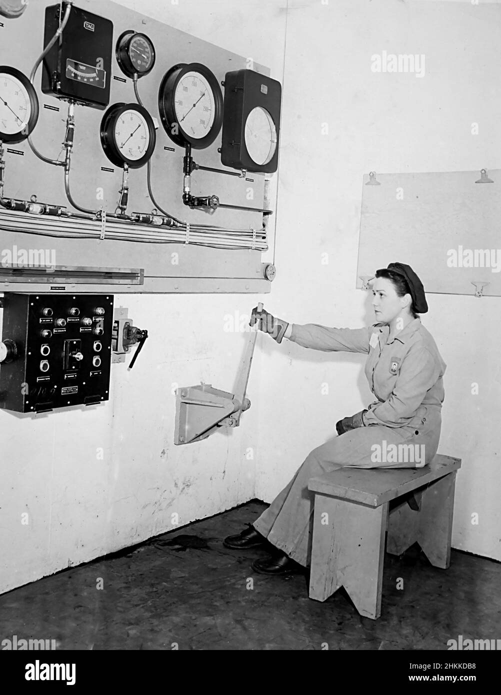 Ein Arbeiter scheint bereit zu sein, den Schalter in einer Fabrik, ca. 1945. Stockfoto