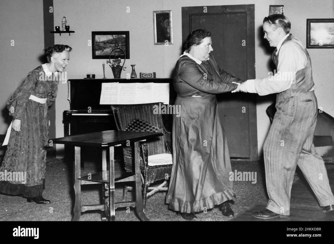 Oma scheint sich gut zu amüsieren, wenn sie mom und Pa beim Tanzen im Salon zusieht, Ca. 1930. Stockfoto