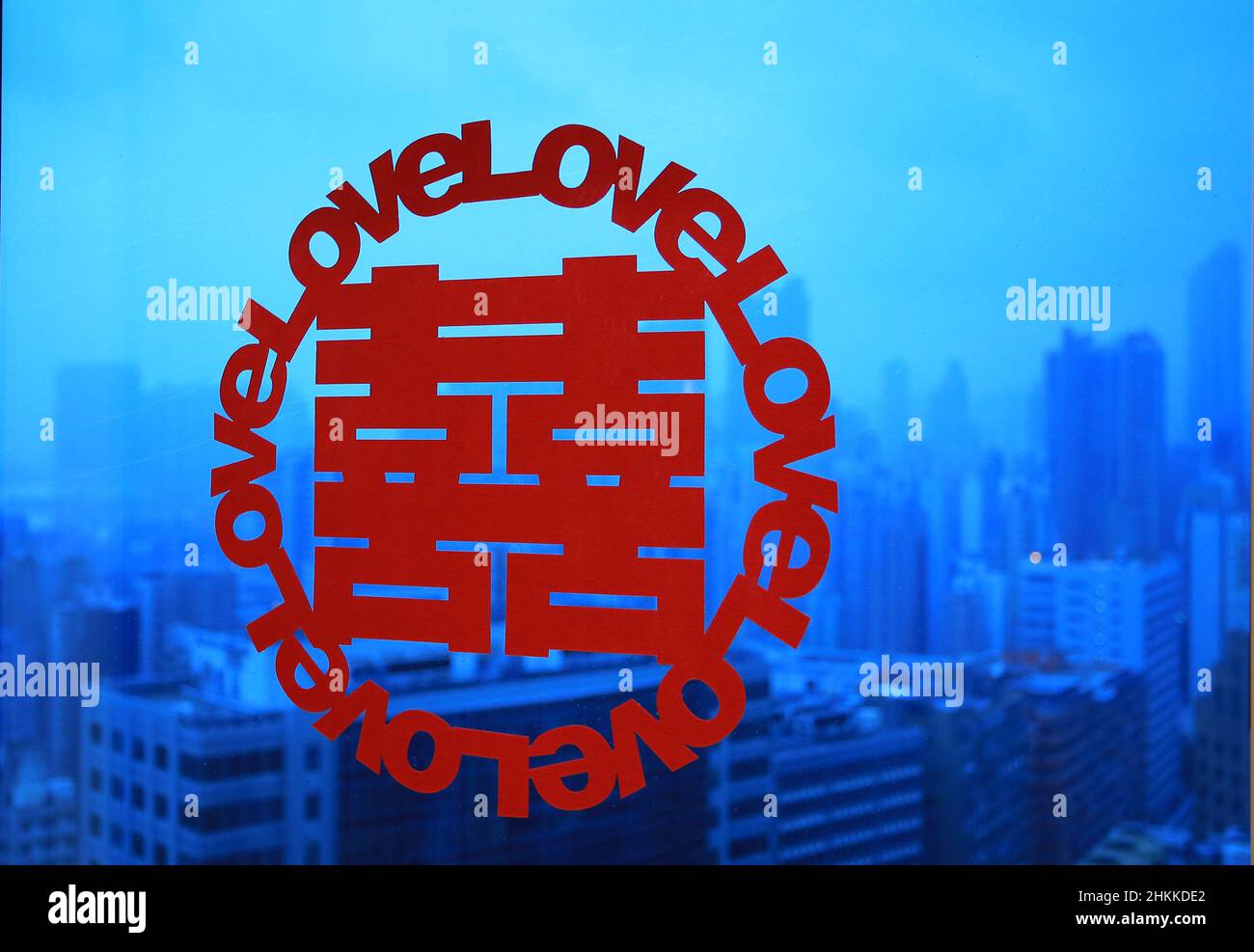 Chinesisches Wort 'glücklich' auf dem Fenster für die Hochzeit mit, mit dem Hintergrund der Stadt Stockfoto