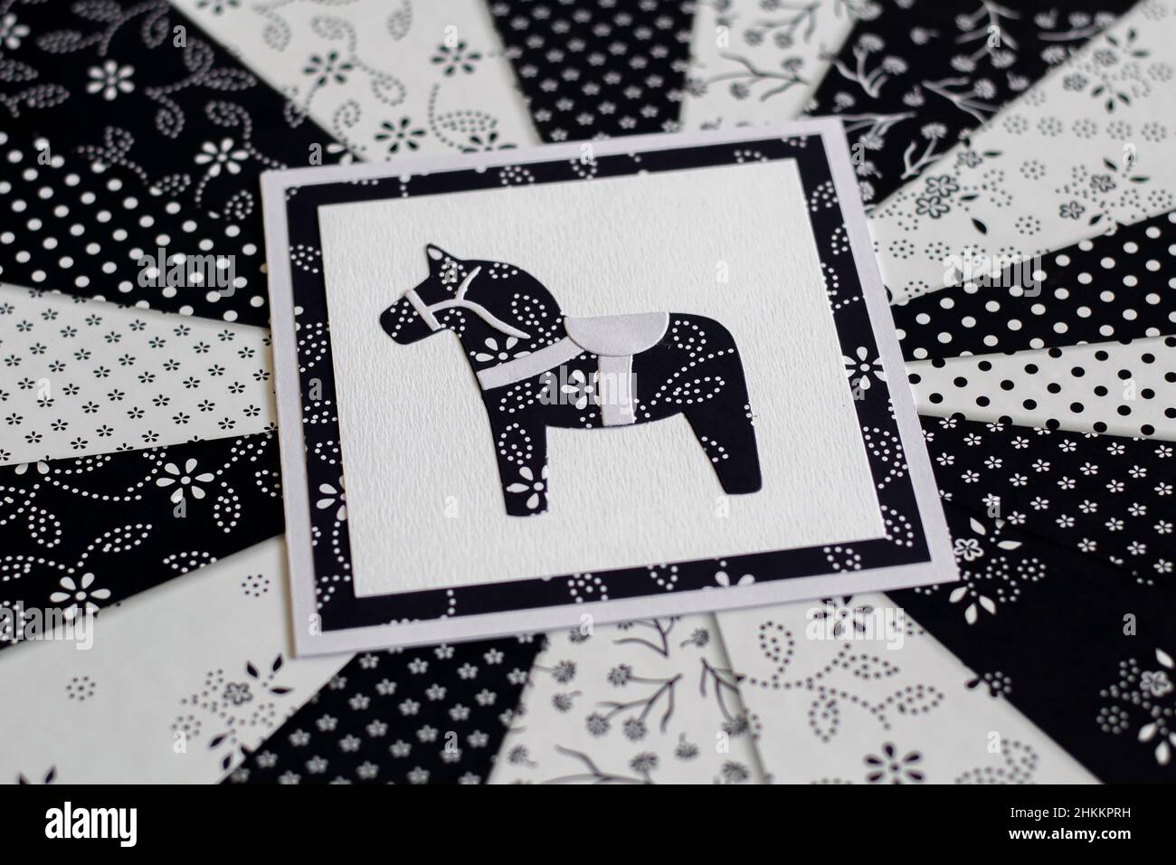 Handgefertigte Grußkarte mit schwedischem Dala- oder Dalakarier-Pferd-Blumenmuster in Schwarz und Weiß. Stockfoto