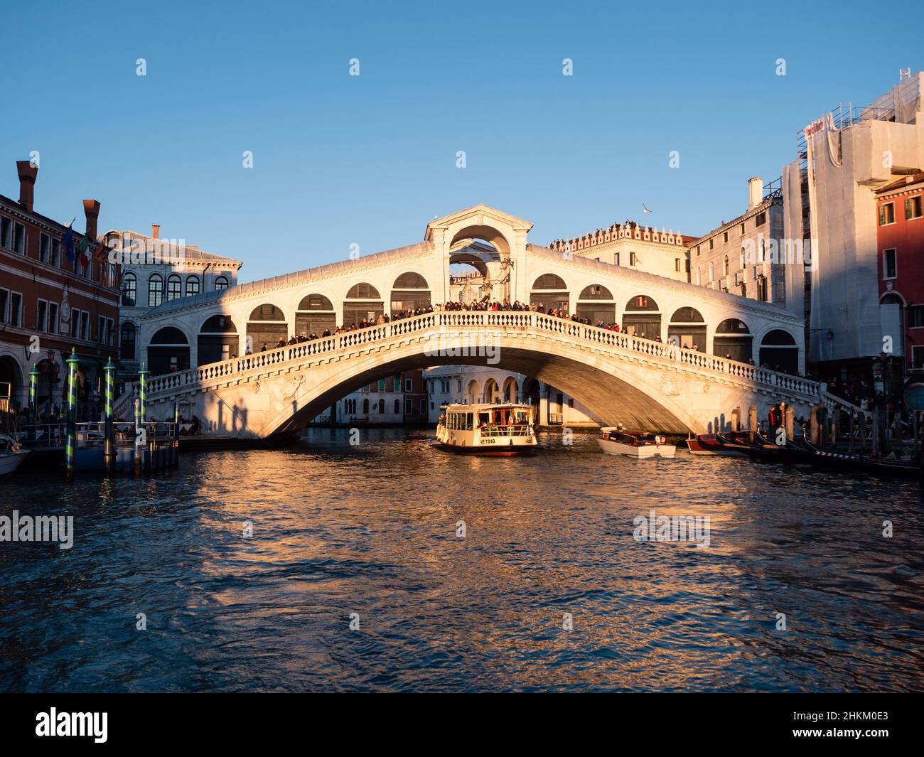 Venedig, Italien - 6 2022. Januar: Vaporetto unter der Rialtobrücke am Abend. Stockfoto