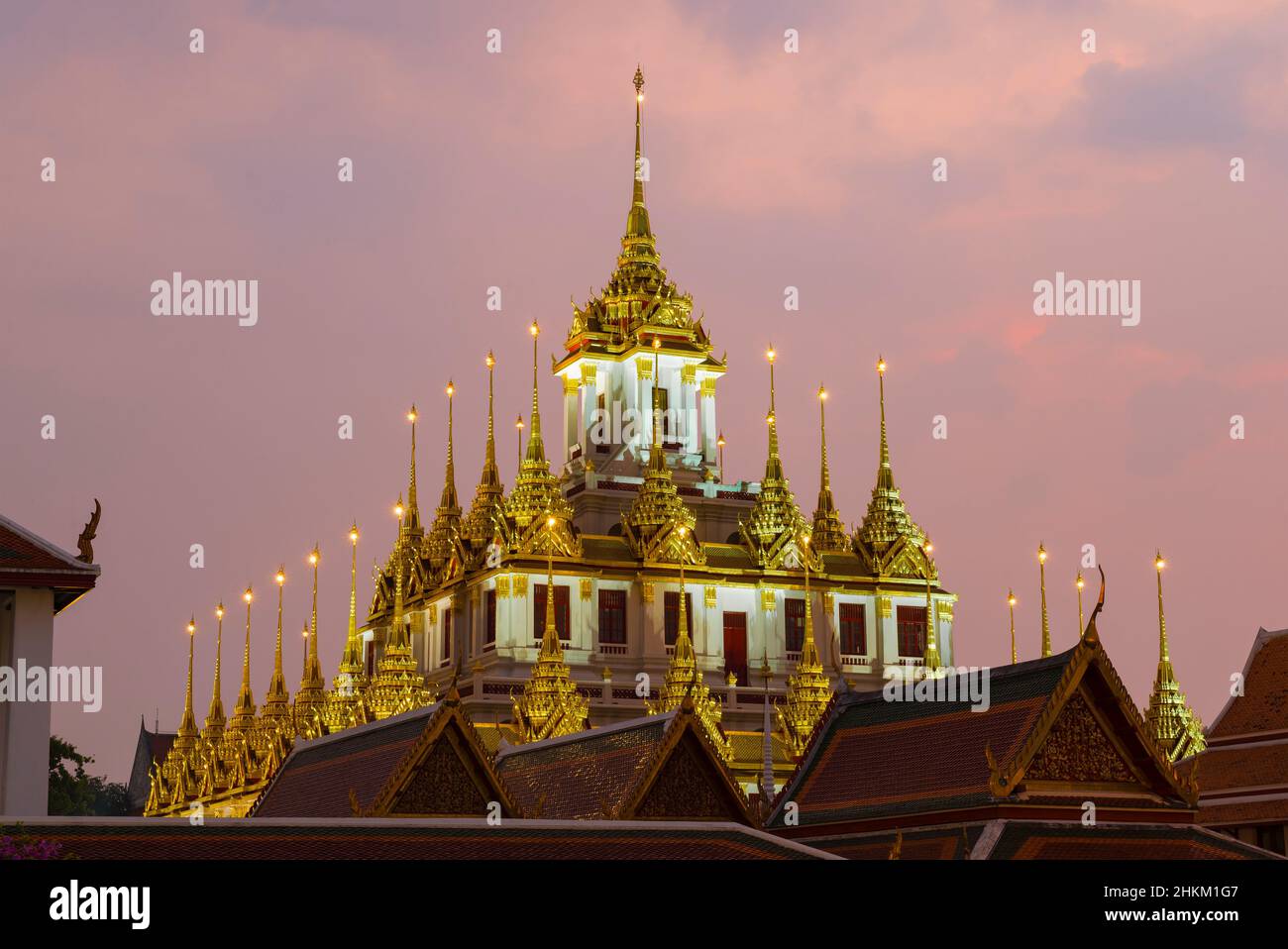Die Spitze der alten Loha Prasat Pagode des Wat Ratchanatdaram Woravihara Buddhistischen Tempels gegen den Abendhimmel. Bangkok, Thailand Stockfoto