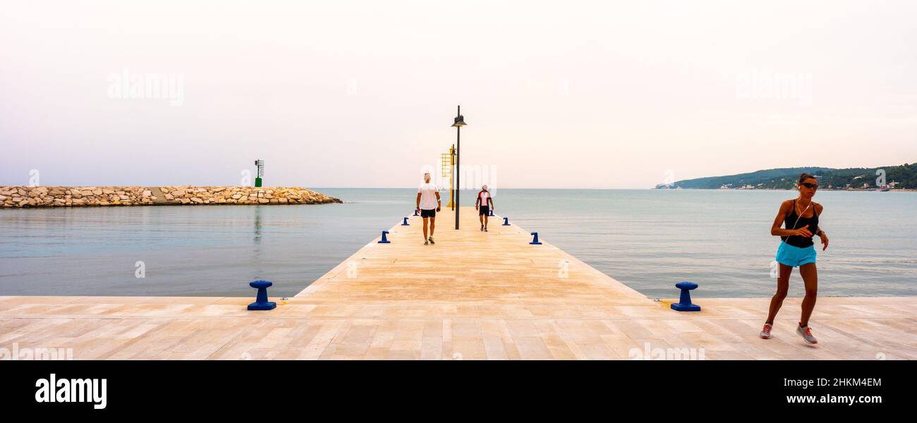 Früh morgens Sport - Menschen trainieren auf Pier von Rodi Garganico in Apulien laufen Stockfoto